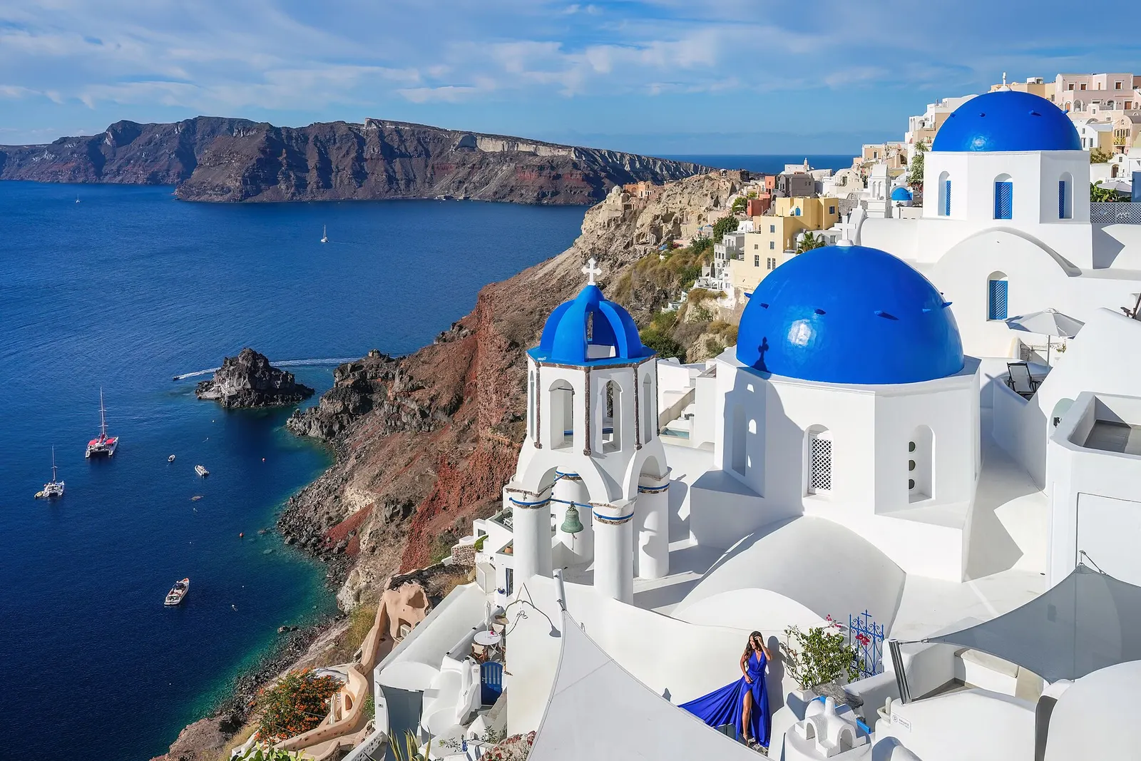 Witte huizen en blauwe koepels van Oia op Santorini boven de caldera